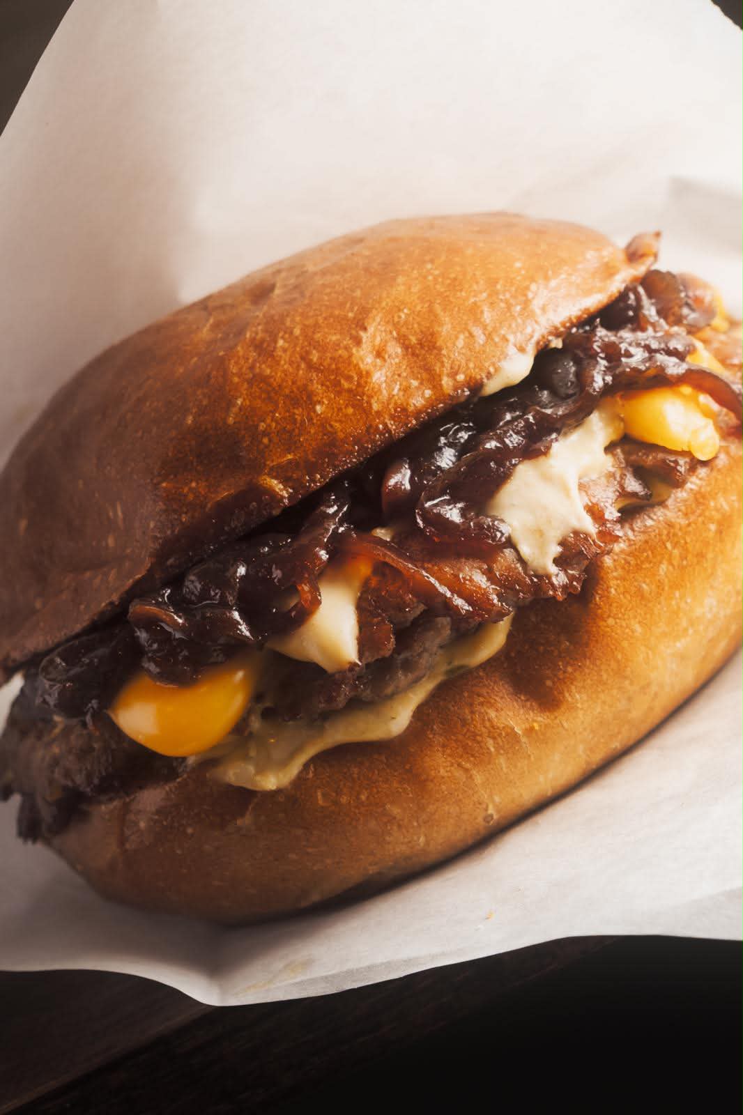 Smash burger Ross Burger con cipolle caramellate e cheddar fuso, primo piano